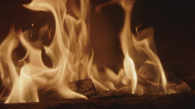 Textures of fire, embers and flames in slow motion inside a fireplace insert in a France house during winter.
