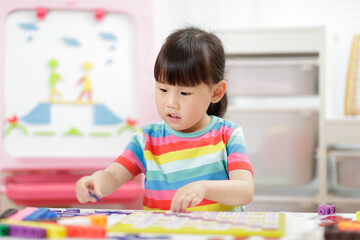 Fototapeta premium young girl play number blocks for homeschooling