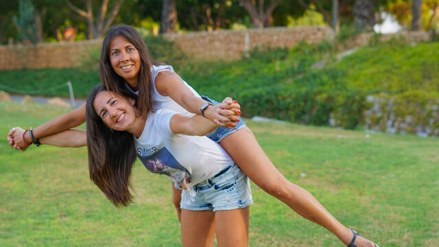 Chivas j&oacute;venes LGTB que son pareja y estan casadas enamoradas jugueteando en un campo de golf muy verde