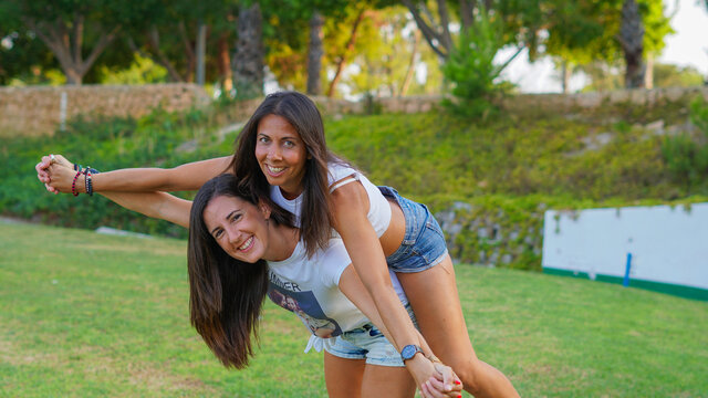 Chivas j&oacute;venes LGTB que son pareja y estan casadas enamoradas jugueteando en un campo de golf muy verde