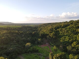 Obraz premium aerial photo of dense forest and abandoned house below