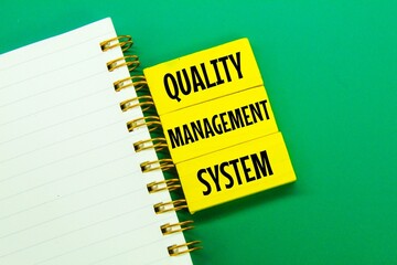 notebooks, colored boards with the words quality management system