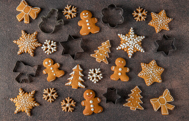 Homemade christmas gingerbread cookies and cookie cutters on brown background, Flat lay, View from above