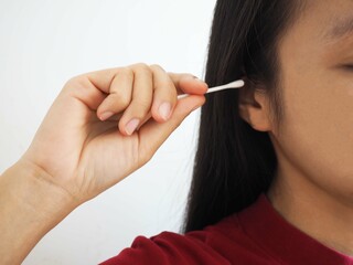 Asian woman cleaning ear with cotton bud. closeup photo, blurred.