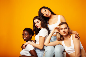 diverse multi nation girls group, teenage friends company cheerful having fun, happy smiling, cute posing on yellow background, lifestyle people concept, african-american, asian and caucasian
