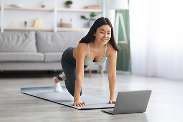 Happy Fit Asian Lady Making Online Sport Trainings At Home With Laptop