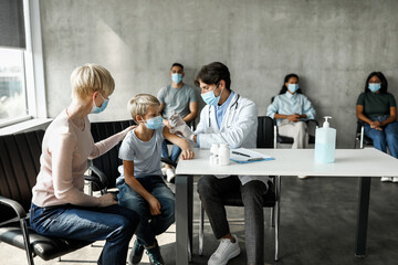 Preteen boy getting intramuscular shot against coronavirus