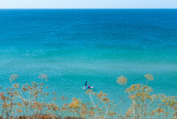Couple practicing paddle in a calm sea