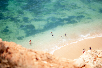 People at the beach swimming view from a cliff