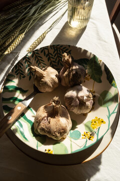 Bowl of garlic near bunch of grass