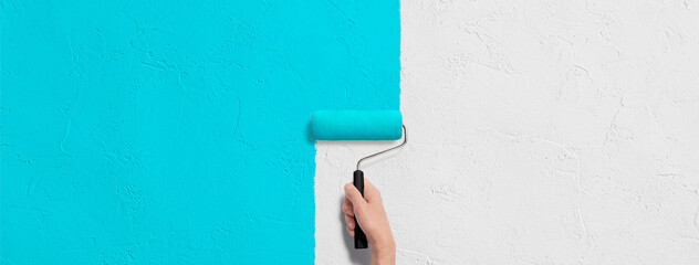 壁にローラーで水色のペンキを塗る手の背景テクスチャー。