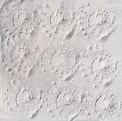 seashell prints on a sand, top view. pattern of imprints of seashells on a beach. summer vacation and travel concept.