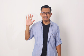 Naklejka premium Young asian man smiling cheerful showing number five with fingers.
