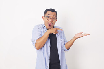 Portrait of asian man pointing something on empty space. Isolated on white with copyspace