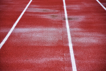 Wet running track close-up at stadium. Puddles after the rain