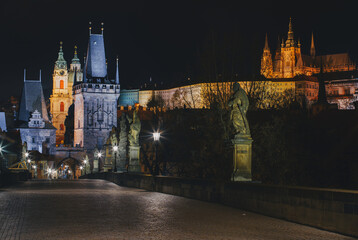 Street lights on the old stone Charles Bridge in the center of the city of Prague On the Vltava river at night and light from the street lights
