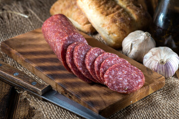 salami on a cutting board with slices.