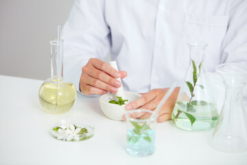 Plants and flowers extract in petri dish and a white background in laboratory , green leaf  in a test tube and doctor for cosmetic advertising , photography science concept