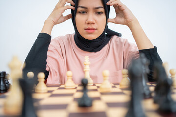 Woman with two hands on head while playing chess