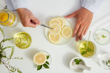 White Background with a doctor for Biological experiment presentation lemon extract and yellow water in biological test tubes. Production of cosmetics based on lemon , top view