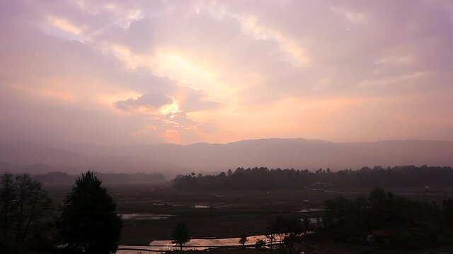 sunrise over mountains with country side farming fields and orange dramatic sky at dawn at village video is taken at ziro arunachal pradesh india.