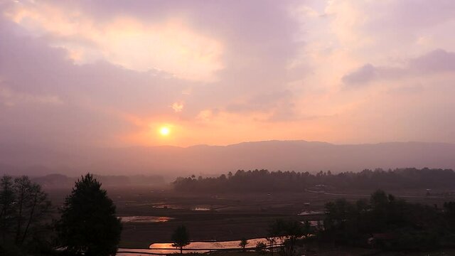 sunrise over mountains with country side farming fields and orange dramatic sky at dawn at village video is taken at ziro arunachal pradesh india.