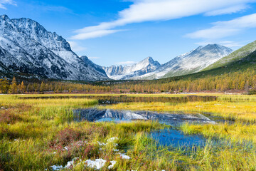 Russia. Magadan Region. A beautiful forest lake against the backdrop of the Big Anngachak mountain range. Autumn in the vicinity of Lake Jack London.