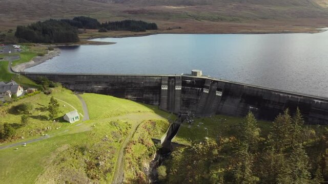 Aerial view of the Spelga Dam on a sunny day, County Down, Northern Ireland. Flying away from the dam and reservoir.
