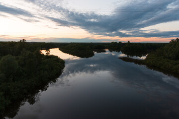dark river waters in the setting sun in summer