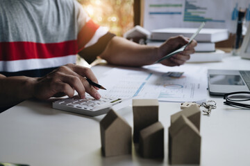 Businessman holding bank savings account and calculating house bill, account or saving money or insurance concept.