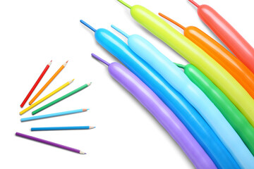 Colorful balloons and pencils on white background