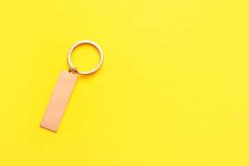 Stylish keychain on yellow background