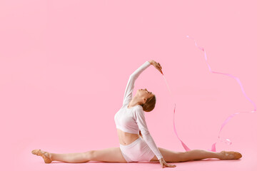 Beautiful young woman doing gymnastics with ribbon on color background