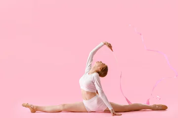 Fotobehang Beautiful young woman doing gymnastics with ribbon on color background © Pixel-Shot