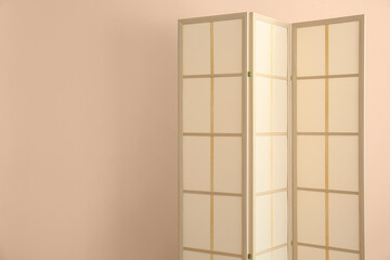Stylish folding screen near wall in room