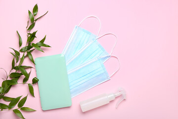 Medical masks with case and green branch on pink background