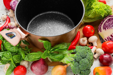 Cooking pot and ingredients for delicious soup on table, closeup