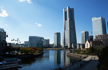 Obraz premium 横浜ランドマークタワー｜西日に輝くビルと水面がとても美しく映える景観です 