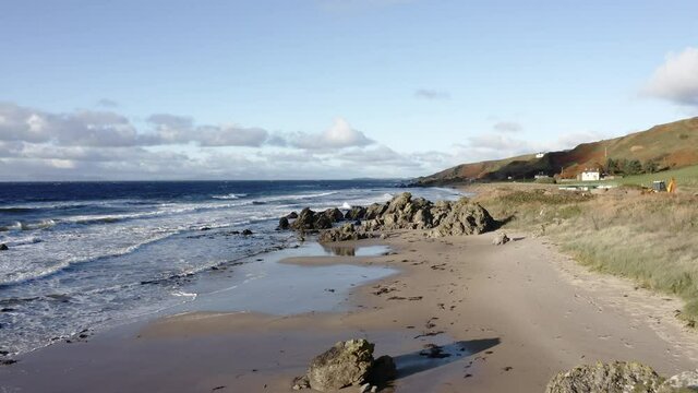 Beautiful aerial shot of an empty beach on the coast of Scotland in summer sun