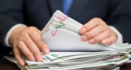 Businessman's hand holding a bundle of papers