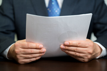 A businessman holding a white paper document