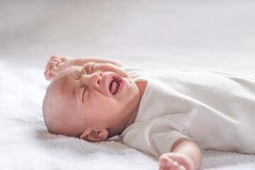 1 month old Asian baby crying in bed