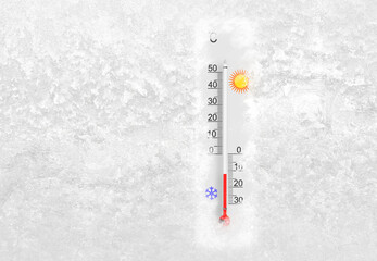 Outdoor thermometer on a frozen window shows minus 12 degrees celsius temperature in cold winter day