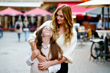 Young mother and school preteen girl making walk in the city. Happy family, woman and daughter with glasses enjoy time together. Love and support of parents. Happiness of mum and child.