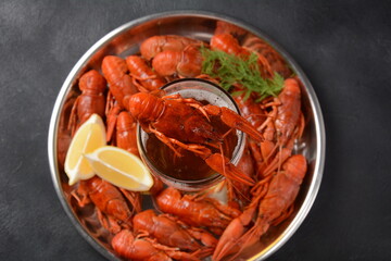Red boiled crawfishes on table in rustic style. Asian Chinese Food Spicy Crayfish on an iron plate with a mug of beer.