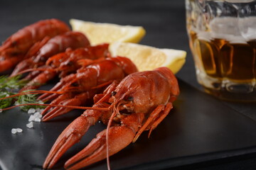 Red boiled crawfishes on table in rustic style. Asian Chinese Food Spicy Crayfish with a mug of beer.