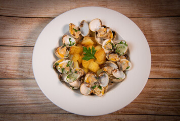 Steamed cockles with fried potatoes in the white dish, mariniere recipe