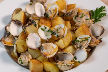 Steamed cockles with fried potatoes in the white dish, mariniere recipe