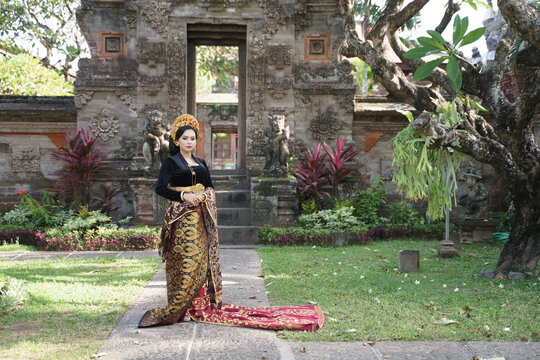 Exotic woman wearing Balinese kebaya and Endek woven fabric