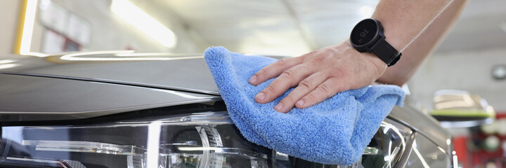 Man cleaning car with microfiber cloth closeup